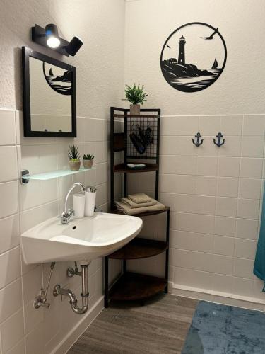 a bathroom with a sink and a lighthouse on the wall at In't Noord Koje in Tossens