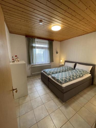 a bedroom with a bed and a wooden ceiling at In't Noord Kombüse in Tossens