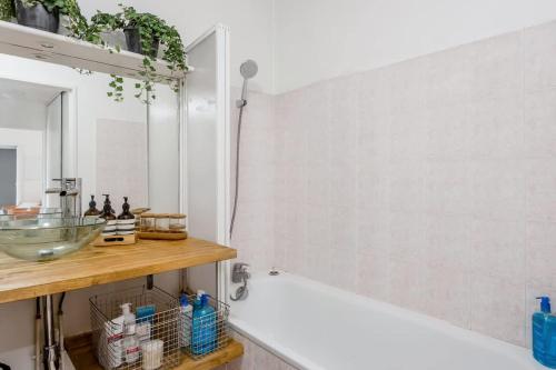 a bathroom with a tub and a sink and a mirror at Passion et détente by UTA HOUSE in Saint-Denis