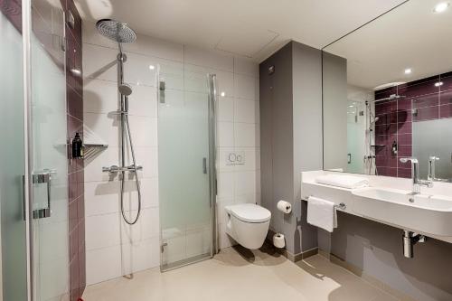 a bathroom with a shower and a toilet and a sink at Premier Inn Hamburg City Klostertor in Hamburg