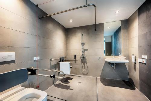 a bathroom with a shower and a toilet and a sink at Premier Inn Wiesbaden City Centre in Wiesbaden