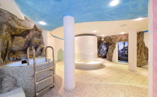 una grande camera con bagno con parete di roccia di Hotel Waldrast a Terento