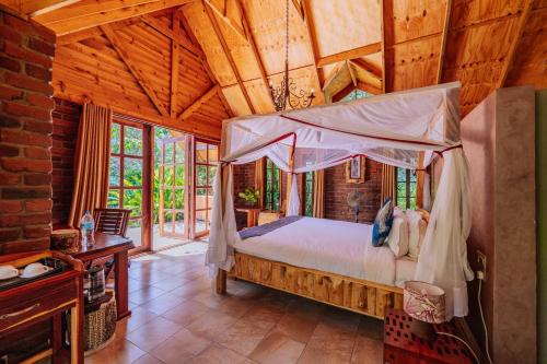 a bedroom with a bed in a room with wooden ceilings at Under The Shade Safari Lodge in Arusha