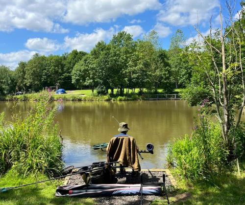 a man is sitting on a boat in the water at Teal Safari Tent in Droitwich