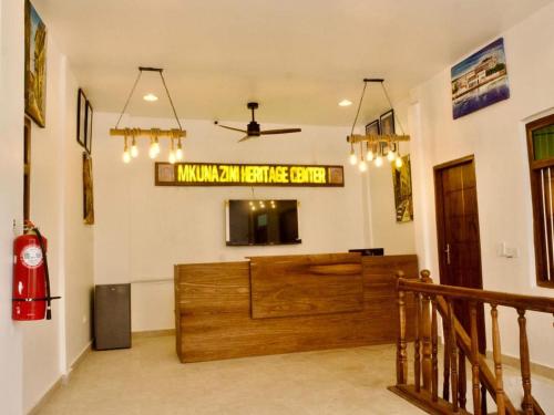 ein Wohnzimmer mit einem großen Holzschreibtisch im Zimmer in der Unterkunft Mkunazini Heritage Hostels in Zanzibar City