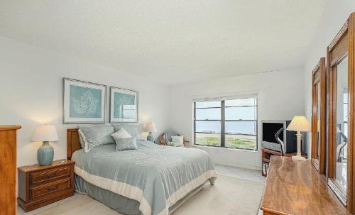 Un dormitorio con una cama y un televisor. en Oceanview Two Bedroom Condo with Beach Access, en Cocoa Beach