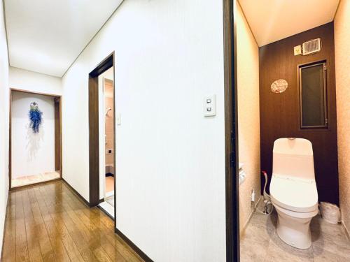 ein Badezimmer mit Toilette und Spiegel in der Unterkunft ZYZ Higashijūjō House in Wada