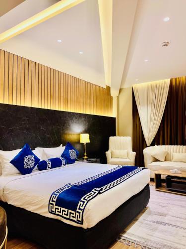 a bedroom with a large bed with blue pillows at Hotel Hillview Islamabad in Islamabad