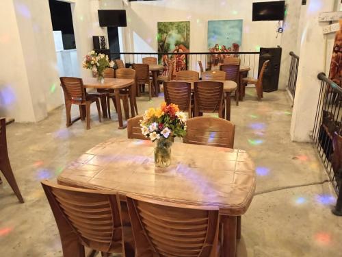 a wooden table with a vase of flowers on it at GT Homes Peradeniya 
