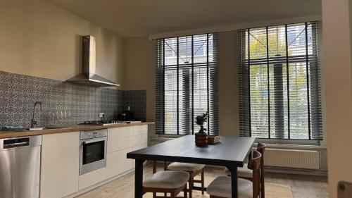 a kitchen with a table and some chairs and windows at Appartment in Lier City Center in Mellet