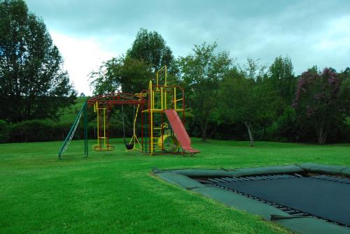 a playground with a slide in a grass field at 20 Mount Champagne in Champagne Valley