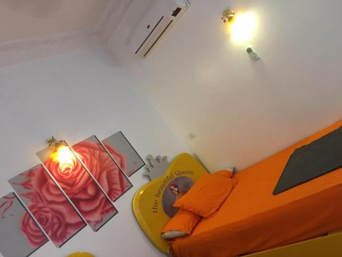 a bedroom with an orange bed and a yellow surfboard at Gana kato in Aswan