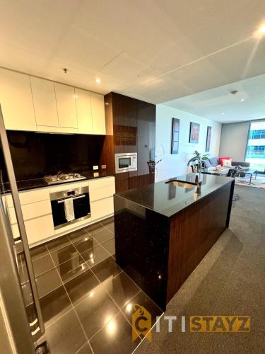 a kitchen with a black counter top in a room at Perfectly Located Modern Apartment - Canberra CBD in Canberra
