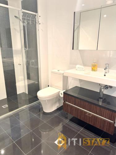 a bathroom with a toilet and a sink and a shower at Perfectly Located Modern Apartment - Canberra CBD in Canberra