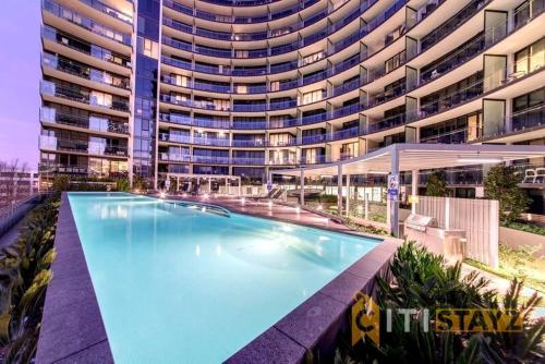 a large swimming pool in front of a large building at Perfectly Located Modern Apartment - Canberra CBD in Canberra