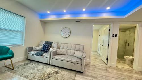 デイトナビーチにあるWavecrest Retreat Near Strip & Beachのリビングルーム(ソファ、壁掛け時計付)