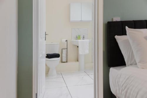 a white bathroom with a sink and a toilet at Large 5BR 3BA Home Leamington Spa Driveway Parking WI-FI in Leamington Spa