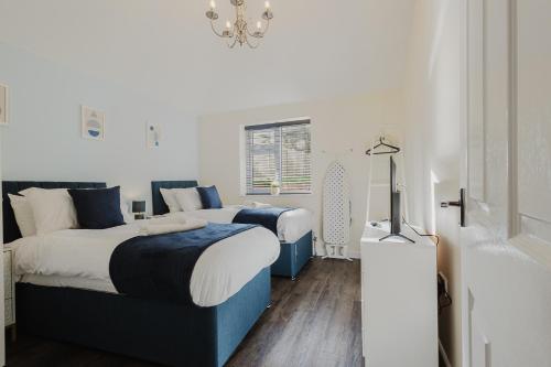 a bedroom with two beds and a window at Large 5BR 3BA Home Leamington Spa Driveway Parking WI-FI in Leamington Spa