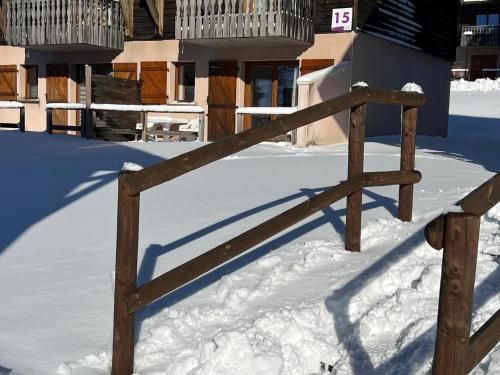a wooden gate in the snow in front of a house at Super Besse chez Sophie 2ch, séjour, wifi, 2tv, rdc, terrasse, parc, piscine, pkg in Besse-et-Saint-Anastaise