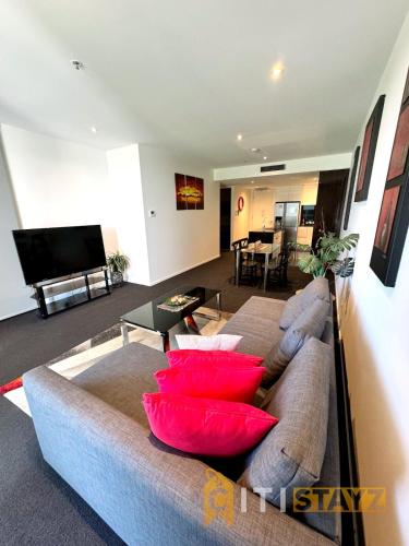 a living room with a couch with red pillows at Perfectly Located Modern Apartment - Canberra CBD in Canberra