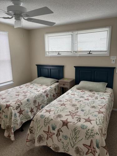 a bedroom with two beds and a ceiling fan at Holgate Ocean Front Duplex 2Nd Fl 14018 in Holgate