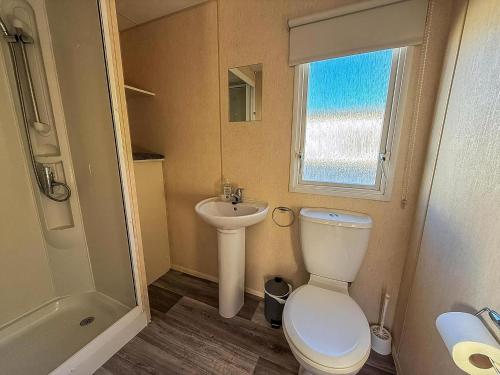 um pequeno banheiro com um vaso sanitário e uma pia em Lovely Caravan For Hire At Manor Park In Hunstanton Ref 23053B em Hunstanton
