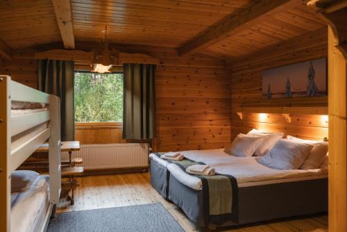 a bedroom with a bed in a wooden room at Harriniva Adventure Resort in Muonio