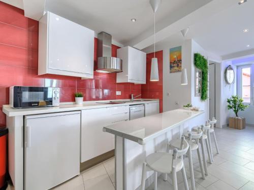 cocina con armarios blancos y paredes rojas en Apartment Ambient by Interhome, en Rovinj