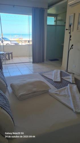 a bedroom with two beds with a view of the beach at Pousada Areia e Mar in Ubatuba