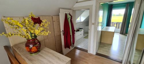 eine Vase mit Blumen auf einem Tisch in einem Zimmer in der Unterkunft Sweet forest cottage near Munich in Oberhaching