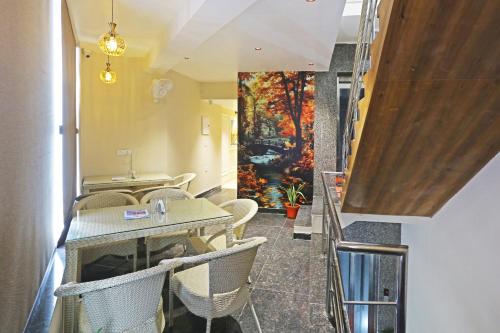 een restaurant met tafels en stoelen en een schilderij aan de muur bij Hotel Nova Inn Near Delhi Airport in New Delhi