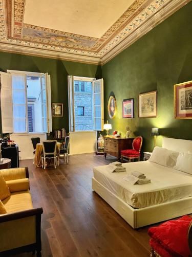a bedroom with a bed and a couch and chairs at Palazzina Fusi in Florence