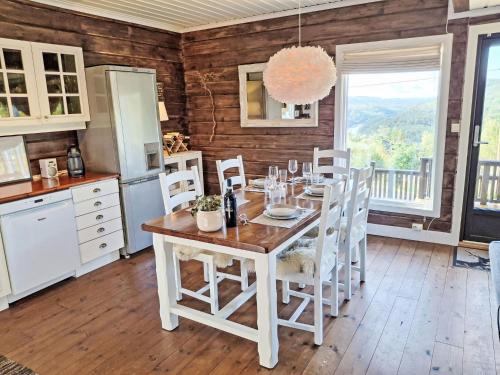 a kitchen with a table and white cabinets and a table and chairs at Holiday Home Kosestua by Interhome in Madland