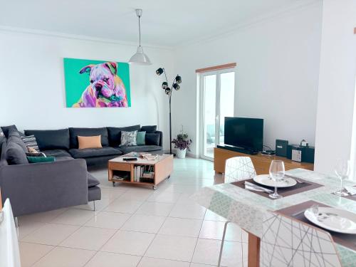 una sala de estar con un sofá y una mesa en Os Dias Felizes, en Tavira