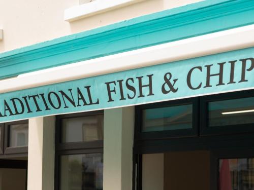 a sign that reads national fish and chips on a building at Holiday Home Spanish Cove - TR4 D4 - Sleeps 5 by Interhome in Kilkee