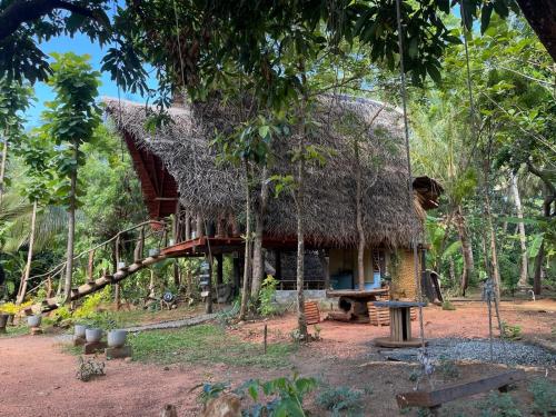 シギリヤにあるSigiri Hunter's Eco Tree lodgeの森の茅葺き屋根の家