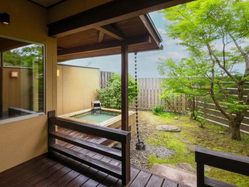a screened in porch with a swing and a pool at 和みの湯宿なかやま in Komagane