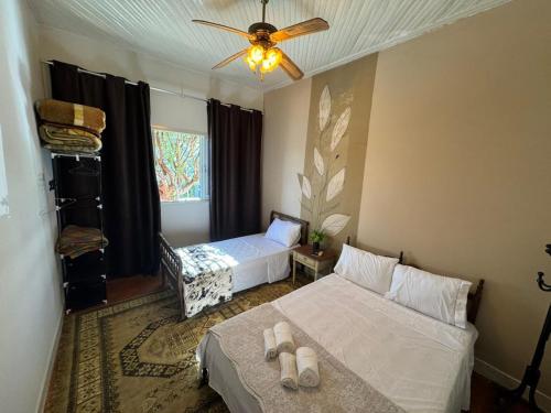 a bedroom with two beds and a ceiling fan at Casa Flores na Janela in Socorro