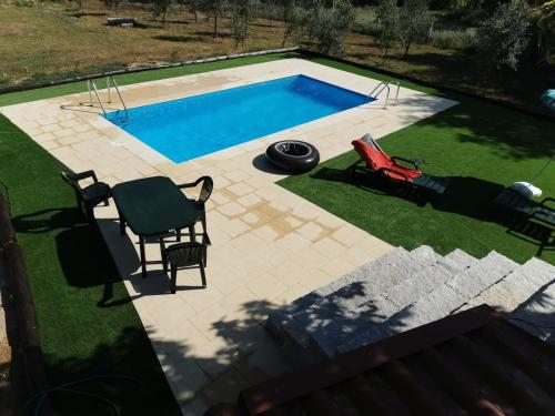 an overhead view of a swimming pool with two chairs and a table at Casa Olho da Lebre Barrocal in Trancoso