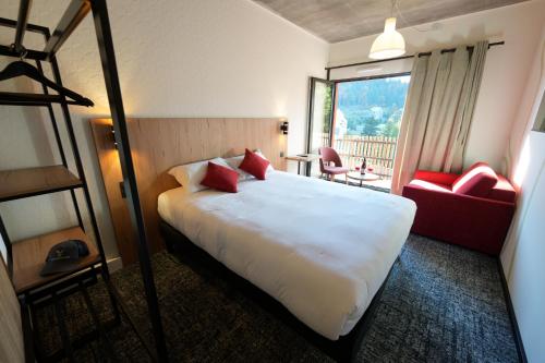 a hotel room with a large bed and a window at Le Rocher Du Cerf in Le Lioran