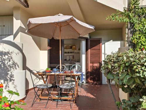 a table and chairs under an umbrella on a patio at Apartment Iris 5- Terza Spiaggia by Interhome in Golfo Aranci