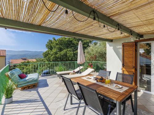 un patio avec une table, des chaises et un parasol dans l'établissement Holiday Home Tonka by Interhome, à Rabac