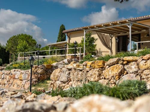a stone wall in front of a house at Holiday Home Poggio Piero 2 by Interhome in Montemassi