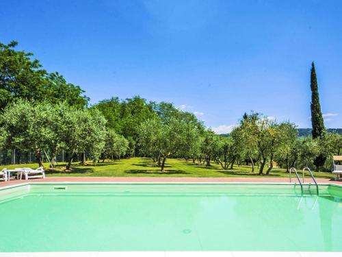 an empty swimming pool with trees in the background at Villa Villa Beboli per 18 pax by Interhome in Lamporecchio