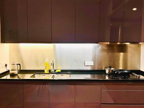 a kitchen with a sink and a stove at Hospitality Service Suites The Mews Klcc in Kuala Lumpur