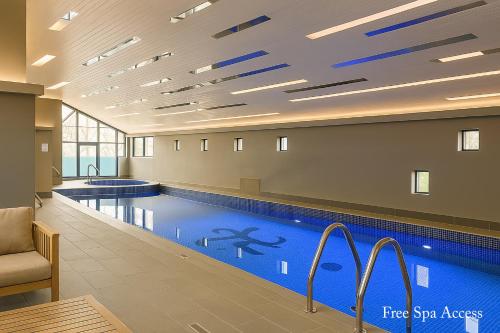 a swimming pool in a building with a large swimming pool at The Rockefeller Apartments in Bowness-on-Windermere