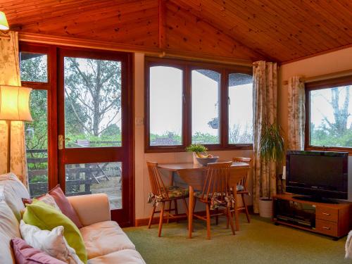 a living room with a couch and a table with a television at Seileachan in Arduaine
