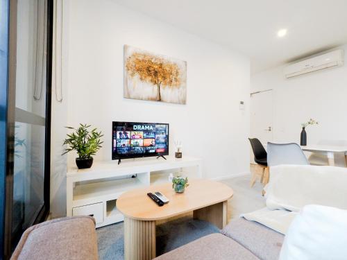 a living room with a couch and a tv at Exquisite and warm 1BR nest in Footscray Pool Gym in Melbourne