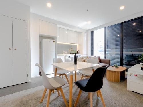 a kitchen and living room with a table and chairs at Exquisite and warm 1BR nest in Footscray Pool Gym in Melbourne