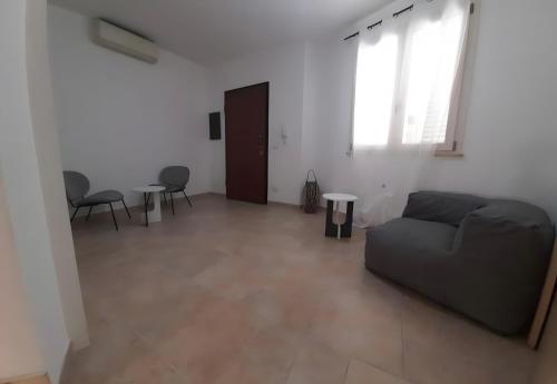 a living room with a couch and chairs and a window at L'angolo Porto Torres in Porto Torres